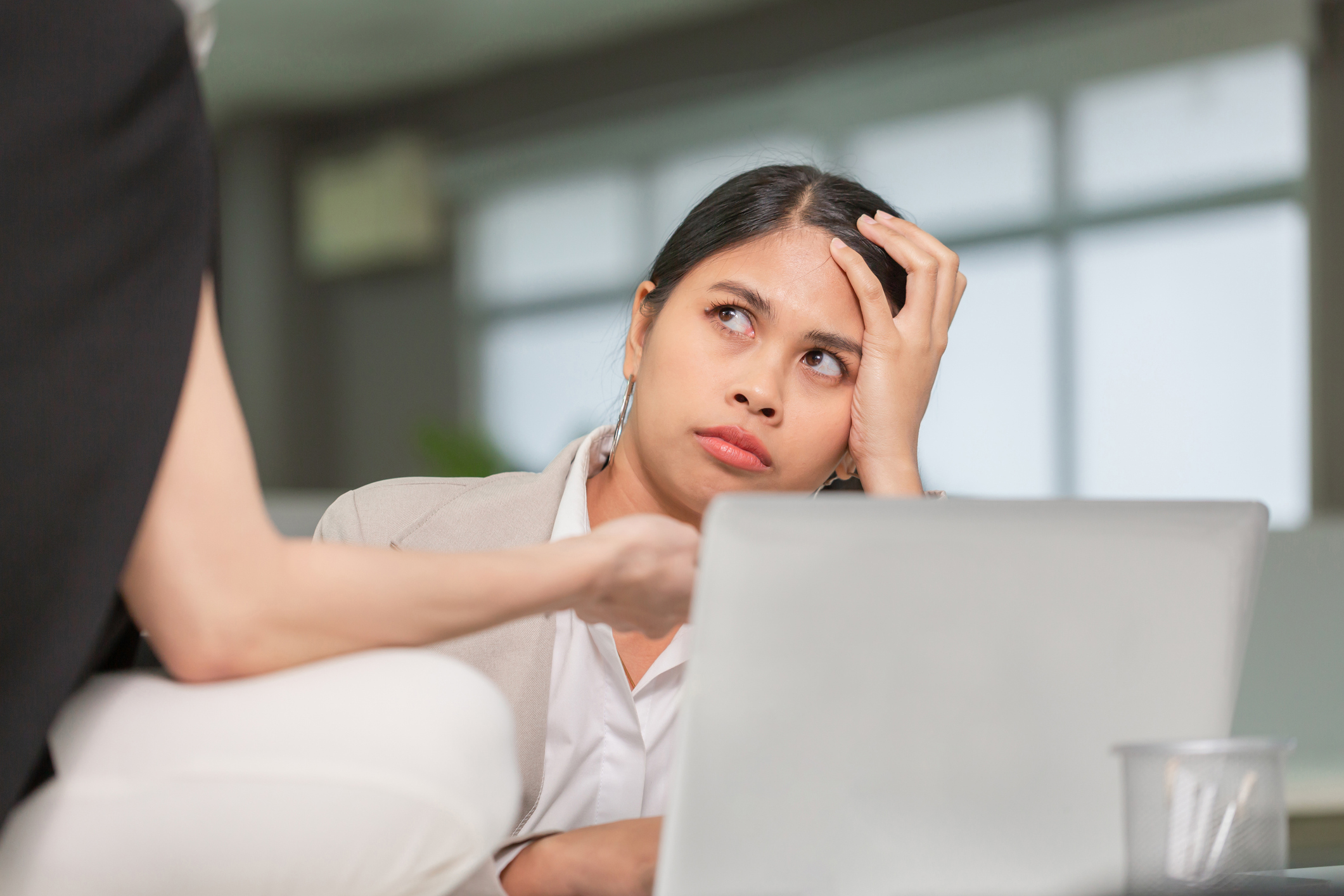 Employee holding head in office, workplace health concern