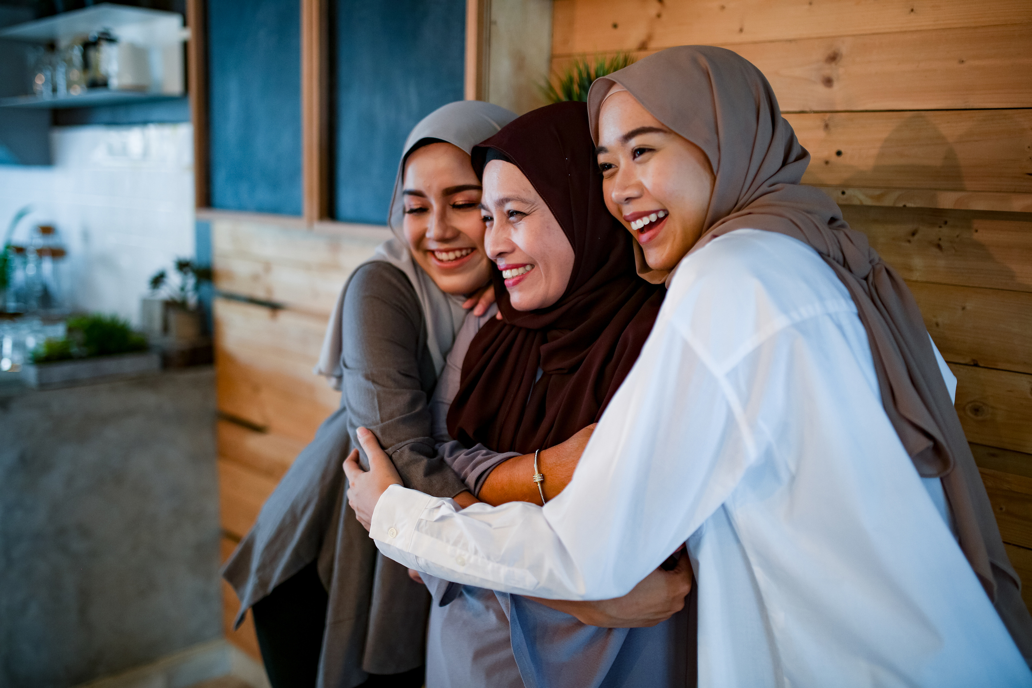 Dua anak perempuan memeluk ibu mereka untuk menunjukkan kasih sayang dan menjaga kesihatan beliau