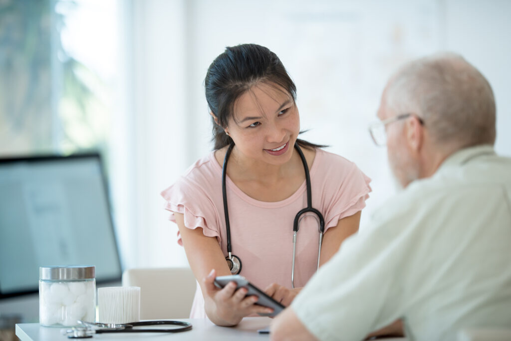 Young female doctor showing healthcare information on a tablet to an elderly man