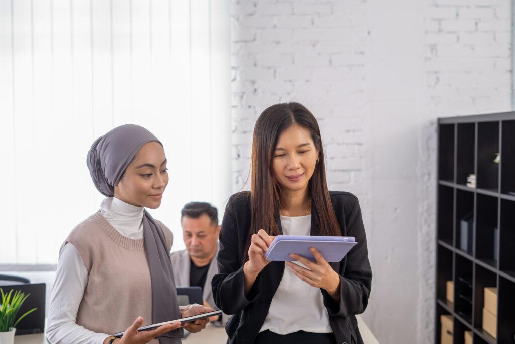 Dua wanita memegang tablet dan mencari pelan langganan kesihatan