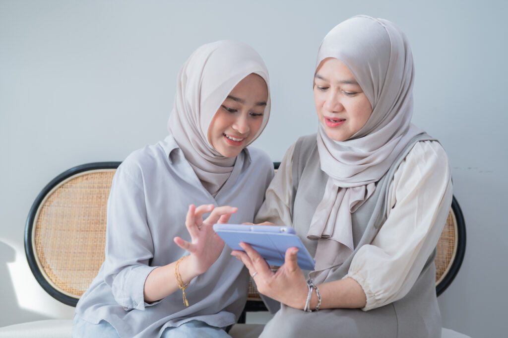 Dua wanita menggunakan tablet untuk akses doktor secara dalam talian