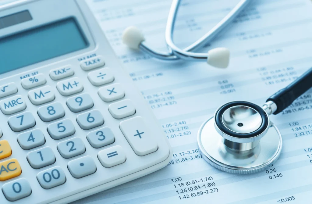 Calculator and stethoscope placed on medical financial documents