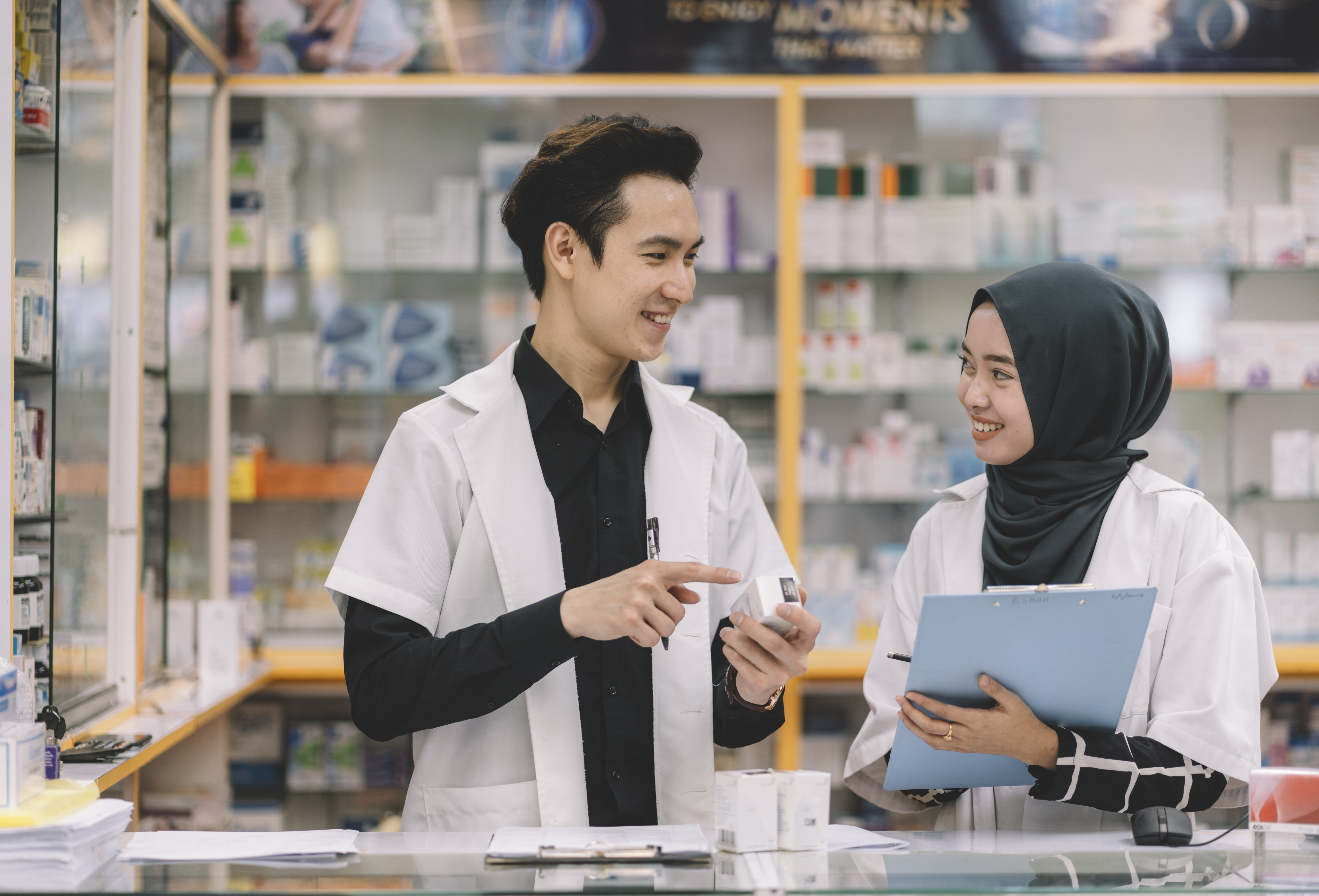 Pharmacists discussing medication inside a pharmacy