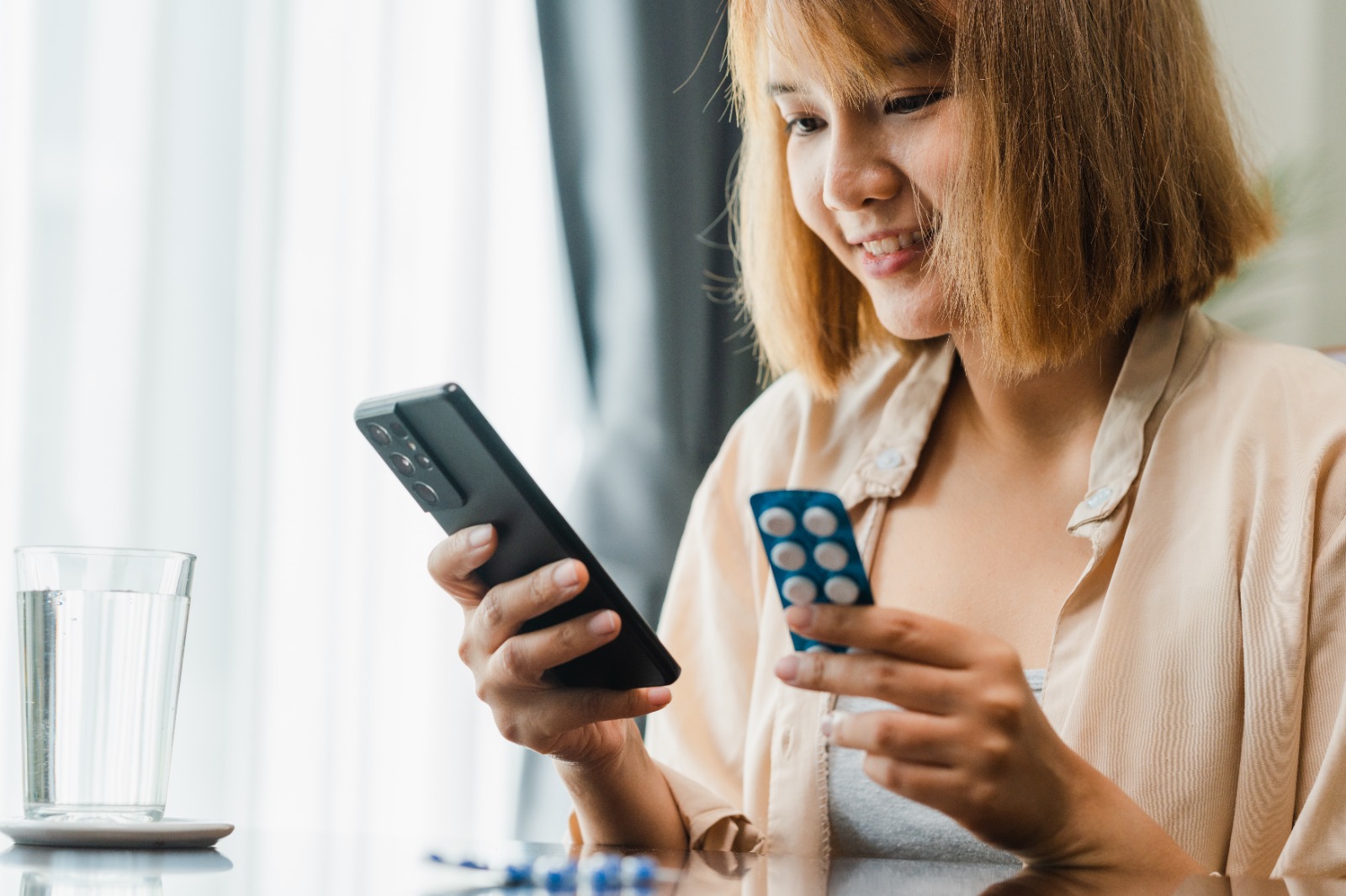 That reads well and flows naturally. `Woman holding a phone and checking medication on WhatsApp`
