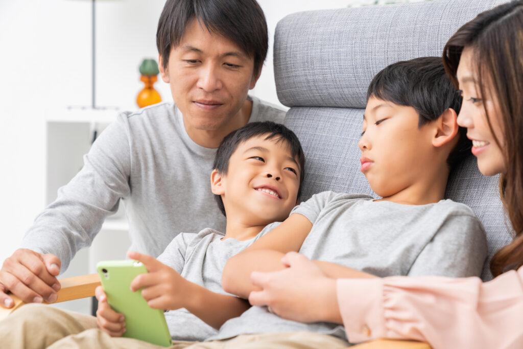Family using a tablet together at home to support Malaysia family health