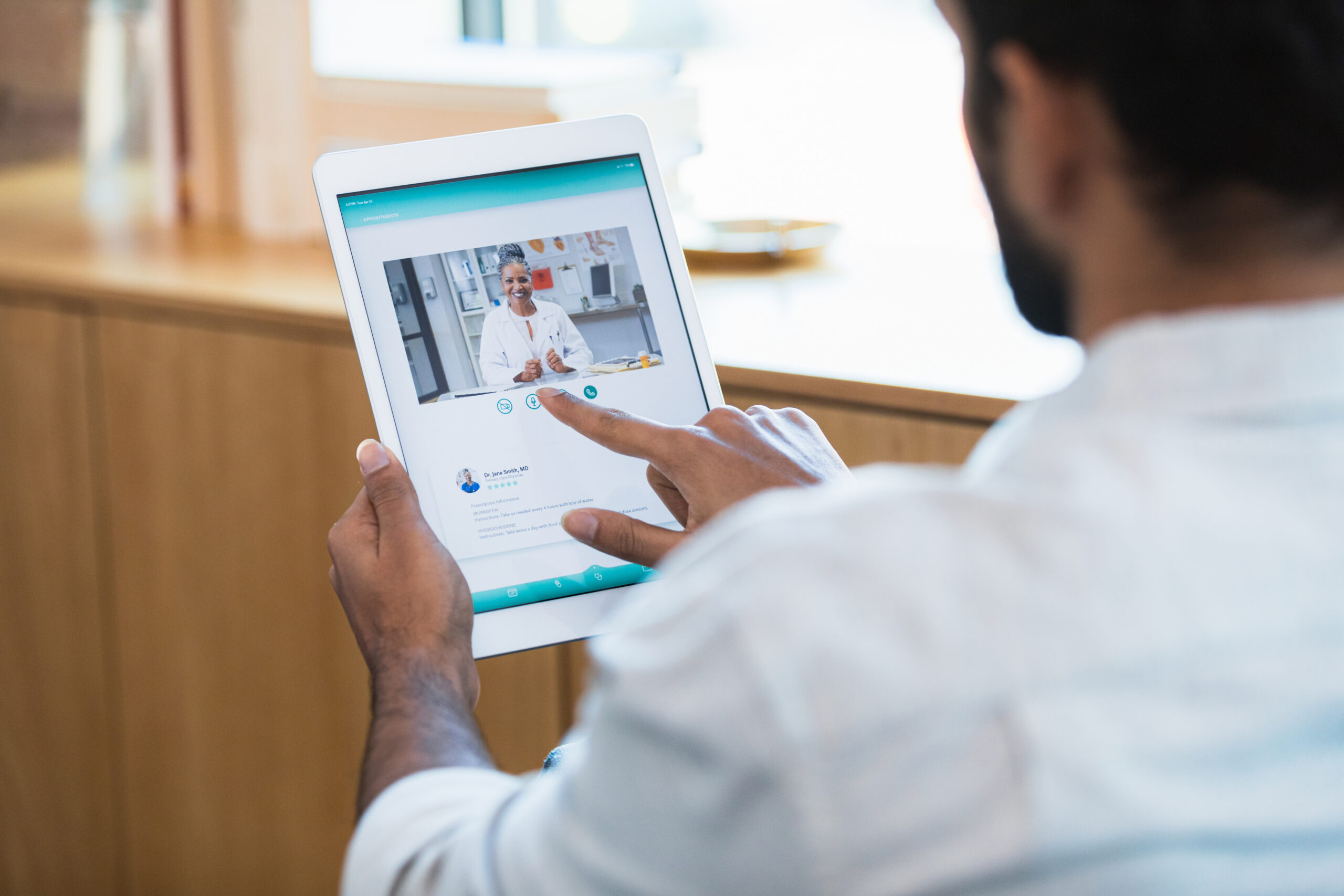Man using a tablet to access telehealth services.