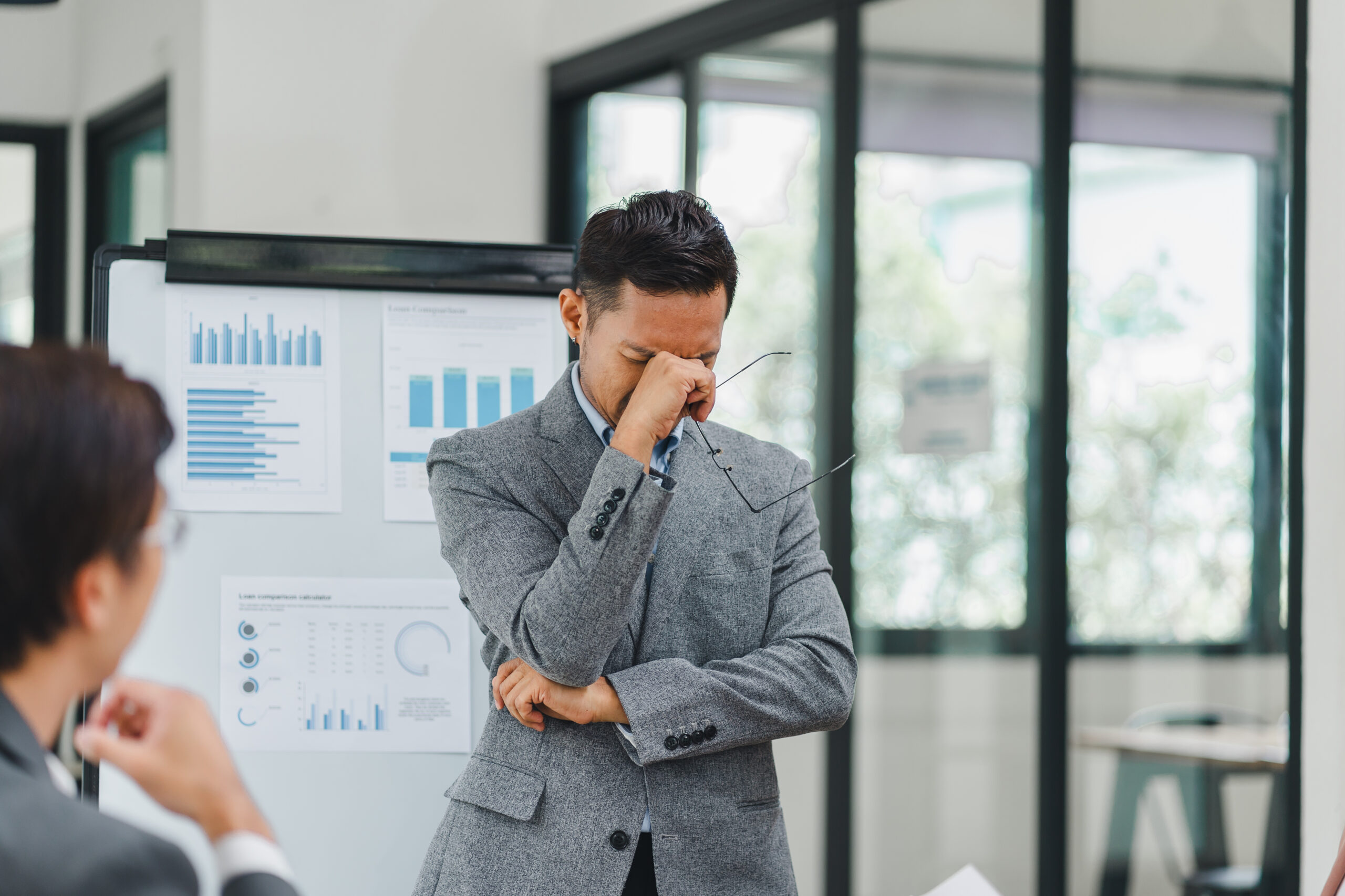 Businessman rubbing his eyes during a presentation while reviewing HR Technology Trends