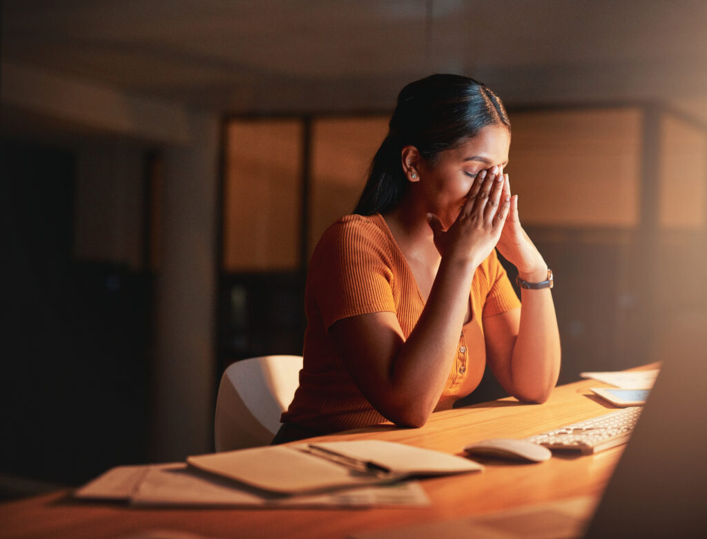 Stressed employee at her desk, concerned about employee productivity Malaysia