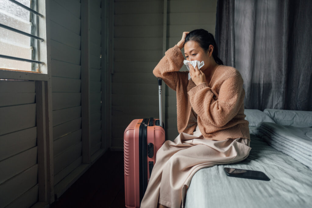 Sick woman resting in hotel room while on travel