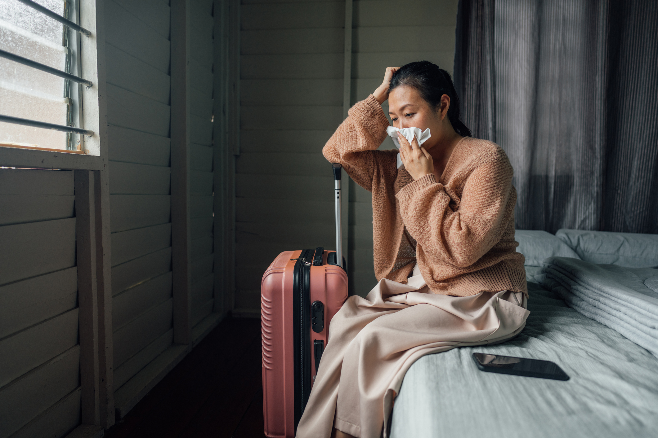 Sick woman resting in hotel room while on travel